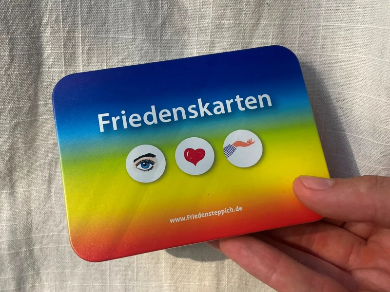 Person hält Friedenskarten mit Symbolen Schachtel in der Hand